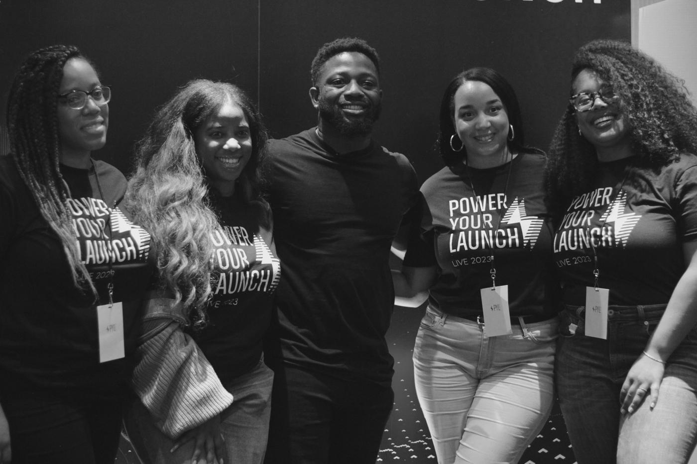 Members of the Power Your Launch team together at an event, wearing Power Your Launch shirts